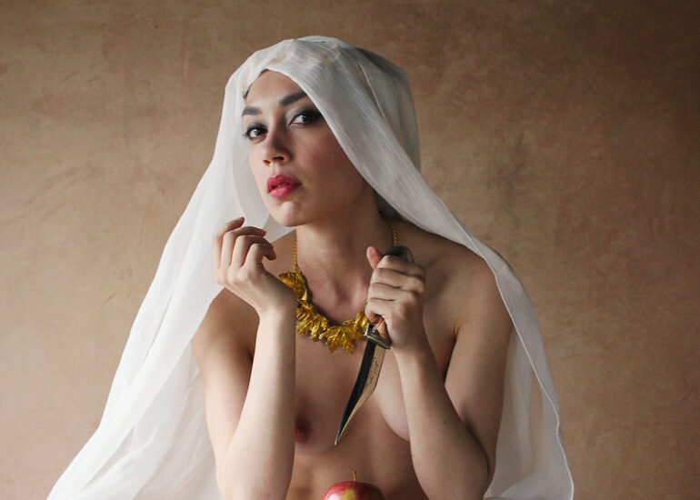 Symbolic fine art nude photograph of a veiled woman holding a dagger and apple, exploring desire, danger, and control.