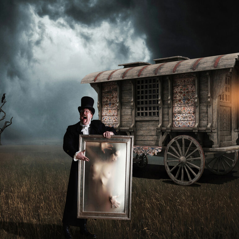 Surreal dark fantasy artwork depicting a Victorian showman holding a framed ethereal nude figure before a mysterious caravan under stormy skies, evoking gothic horror, illusion, and theatrical spectacle.