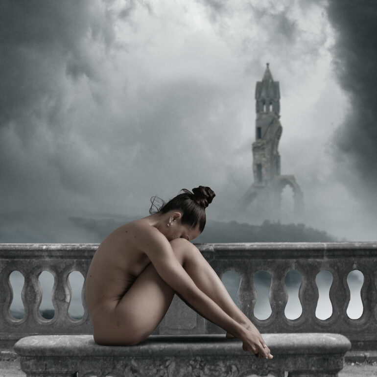 Atmospheric surreal fine art nude artwork of a woman curled on a stone bench beneath storm clouds and distant ruins.